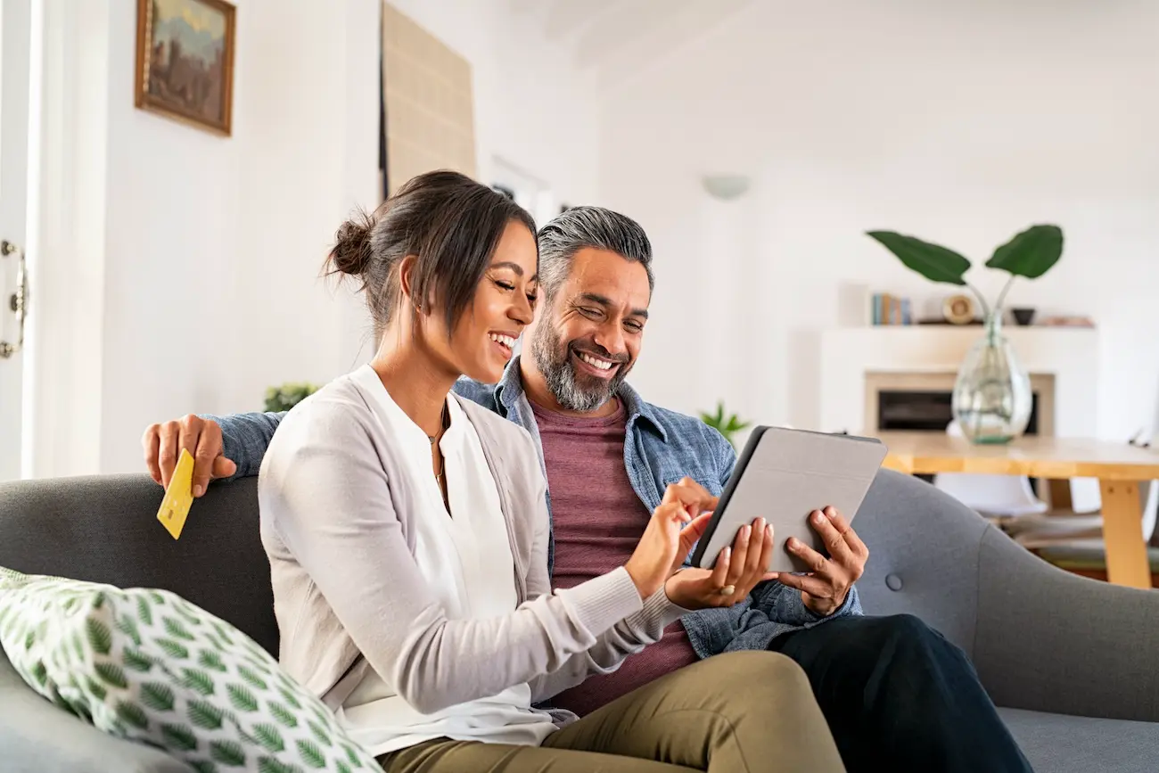 Happy Couple Looking at home at computer screens