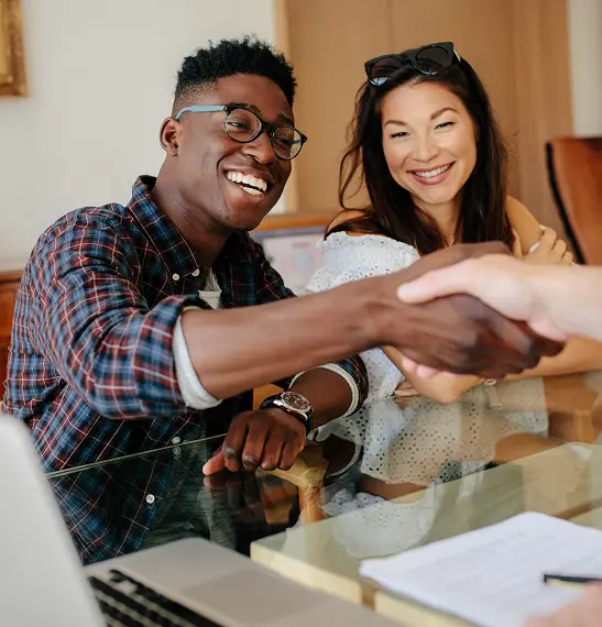 Happy couple handshake with real estate agent.
